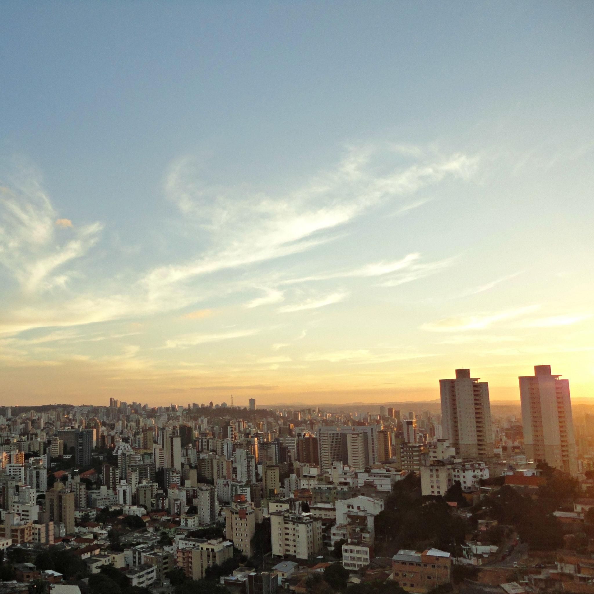 Imagem mostra a vista do bairro Serra, com o pôr do sol e o horizonte ao fundo.